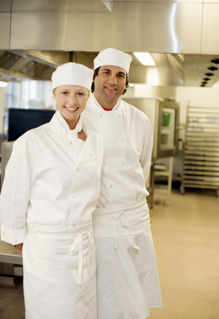 Two chefs in a kitchen smiling