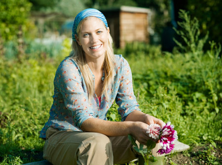 Portrait of a woman sat in a gardenの写真素材