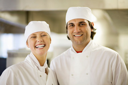 Two chefs in a kitchen smiling