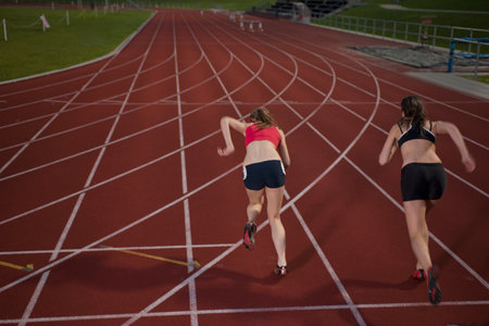 2 female athletes sprinting away
