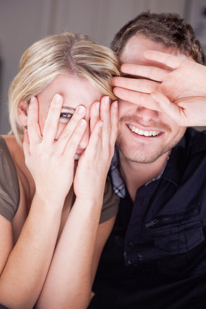 couple hiding behind their handsの写真素材