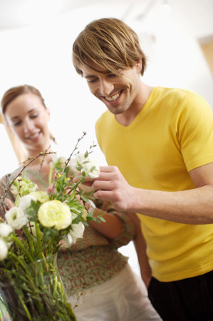 Young couple arranging flowersの写真素材