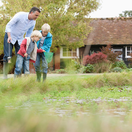 Father and sons by pondの写真素材