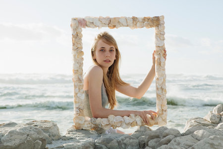 Girl holding shell picture frameの写真素材