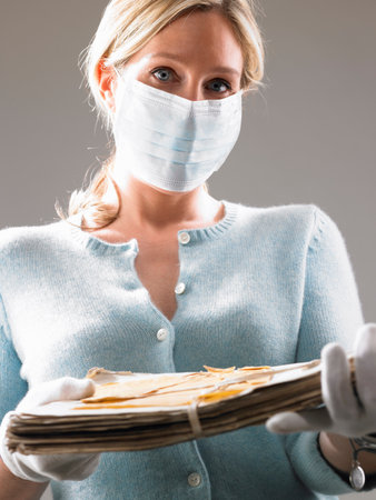 Woman with mask, holding precious filesの写真素材