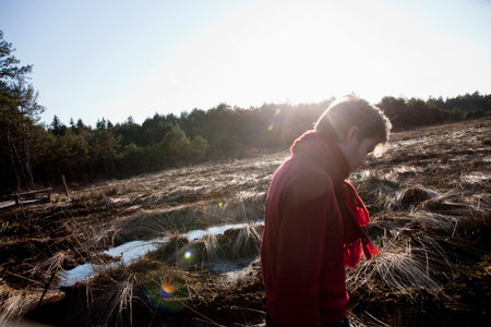Man walking through sunlit forest scene