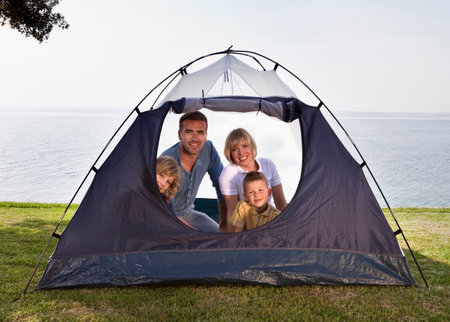 Family camping with tent by seaの写真素材
