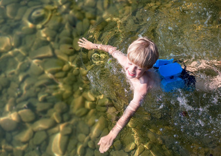 Boy swimming with swimming beltの写真素材