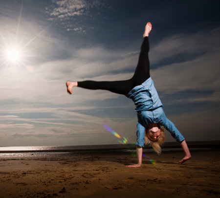Woman cartwheeling on beachの写真素材