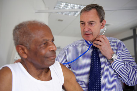 Doctor with stethoscope with elderly manの写真素材