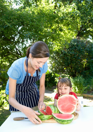 Mother and daughter prepare water melonの写真素材
