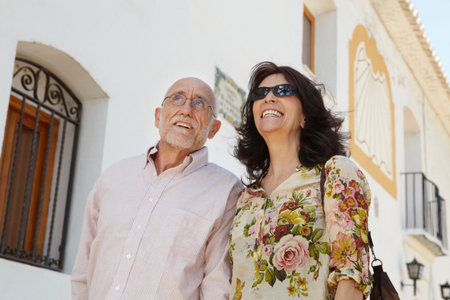 Older couple strolling past old churchの写真素材