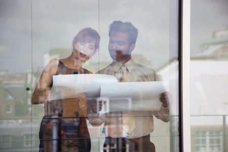 Two work colleagues discussing paperworkの写真素材