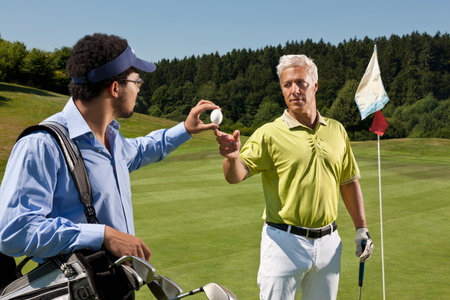 Caddy gives an egg to another golferの写真素材