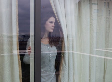 Woman looking out of windowの写真素材