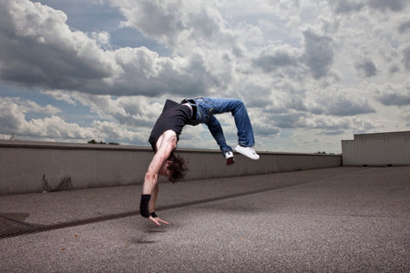 Young man jumping backwardsの写真素材
