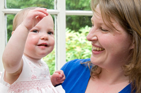 Mum and Daughter by window happyの写真素材