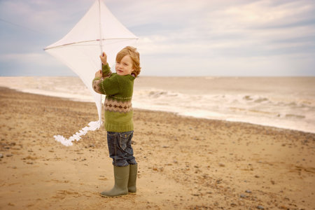 Young boy on beach holding kite. Fallの写真素材