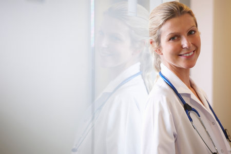 Doctor against a window, smilingの写真素材