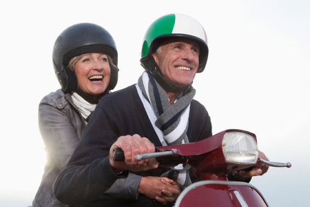 Senior couple on scooterの写真素材