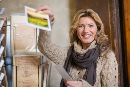 Woman showing a postcardの写真素材