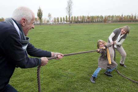 Grandparents and girl playing tug-of-warの写真素材