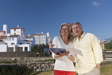 Mature couple holding real estate bookletの写真素材