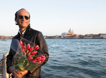 Man with a bouquet in his handsの写真素材