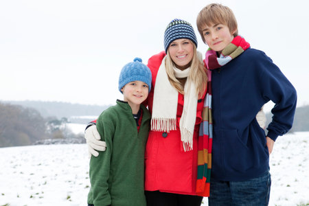 A mother and her sons in the snowの写真素材