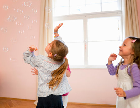 Girls playing with bubbles togetherの写真素材