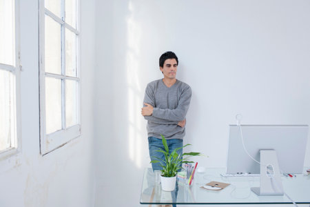 Man standing in an office arms crossed