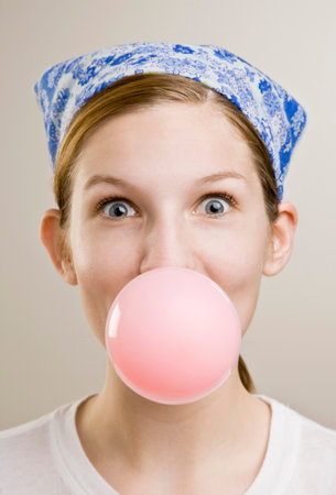 Woman blowing a bubble with gumの写真素材