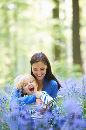 Mother and son reading in forestの写真素材