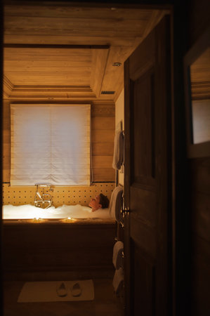 Woman relaxing in bath at ski chaletの写真素材