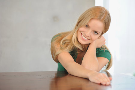 Smiling woman sitting at tableの写真素材