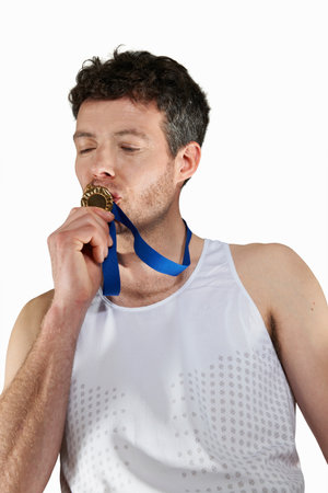 Man in running gear kissing medalの写真素材