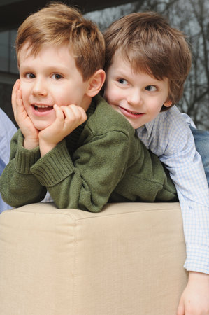 Boys sitting on sofa togetherの写真素材