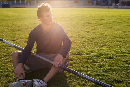 Man sitting with pole on grass