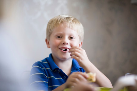 Boy eating at dinner tableの写真素材