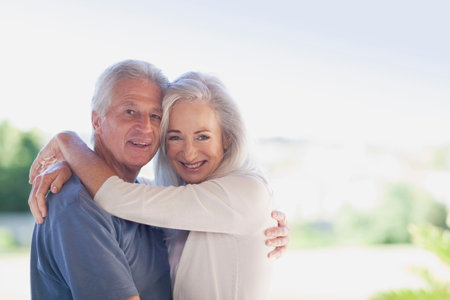 Older couple hugging outdoorsの写真素材