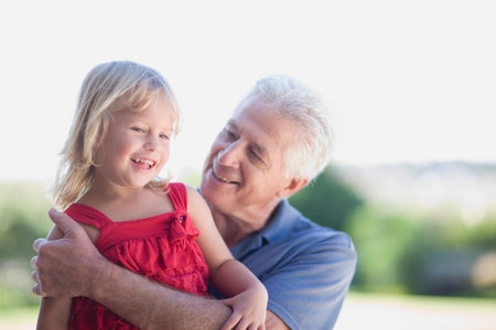 Grandfather hugging granddaughterの写真素材