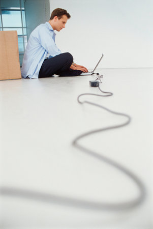 Businessman using laptop on floorの写真素材