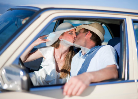 Newlywed couple kissing in carの写真素材