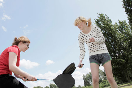 Girls playing with rackets in parkの写真素材