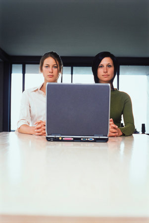 Businesswomen using laptop togetherの写真素材