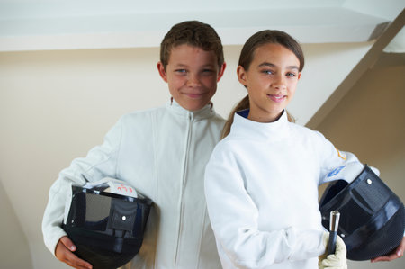 Children wearing fencing costumes