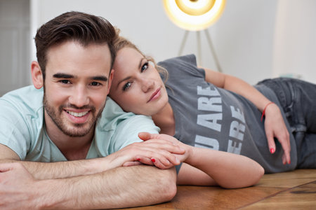 Smiling couple embracing on floorの写真素材