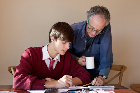 Father helping son with homeworkの写真素材