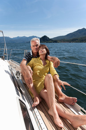 Older couple relaxing on sailboatの写真素材