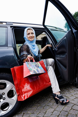 Woman in headscarf with shopping bagsの写真素材